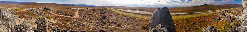 A panoramic view from Finger Mountain along the Dalton Highway.  This is one of the more developed rest stops along the highway, and the view is vast and spectacular.  The "finger" that gives Finger Mountain its name is sticking up in the distance behind the cars in the parking lot. From Dalton Highway in Alaska.