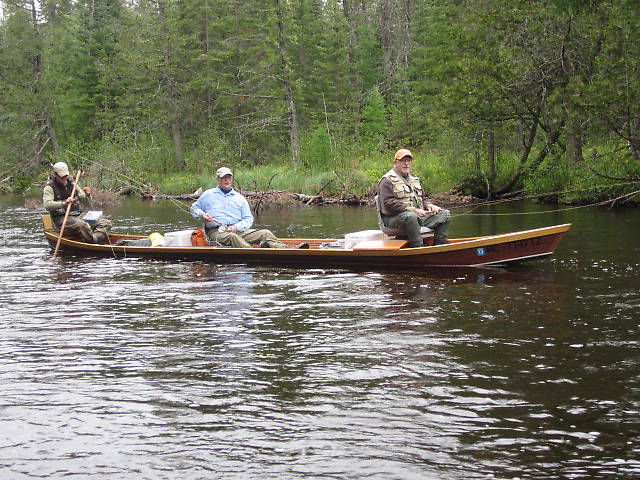 Au Sable River Boat...Also called a "Stick-Boat"...Still being made along the Au Sable and dating back to the logging days. Was used to pole upstream supplies etc to logging camps. Makes a great platform for fishing as well. Chains are used and you float at current speed for long drag free floats. That's Joe in the rear there hiding from the camera. He guides out of Gates' Au Sable Lodge.